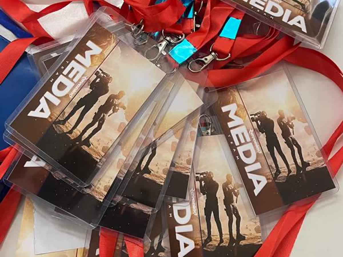 A fan of Media Team accreditation badges in clear holders, attached to red lanyards