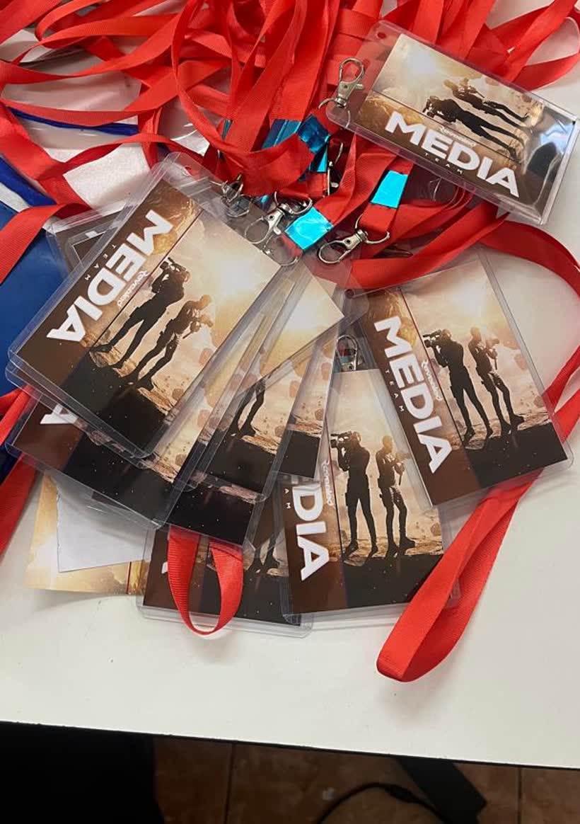 A fan of Media Team accreditation badges in clear holders, attached to red lanyards